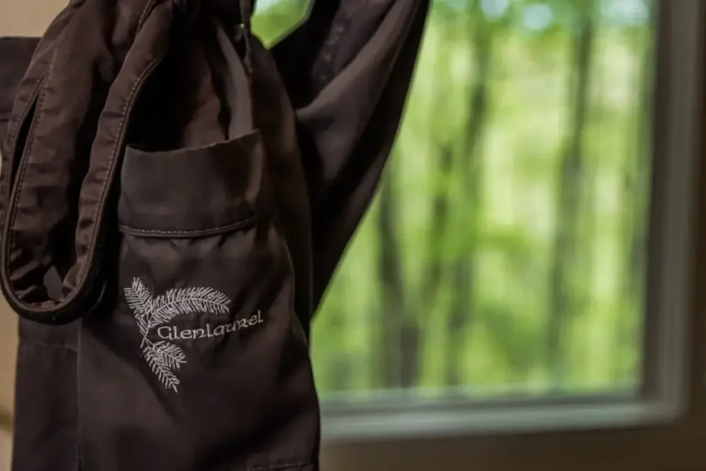 A dark brown fabric item with a "GlenLaurel" logo hanging near a window with a blurred view of trees.